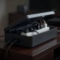 Power strip tucked inside a closed cable management box with two cords leaving through end slots